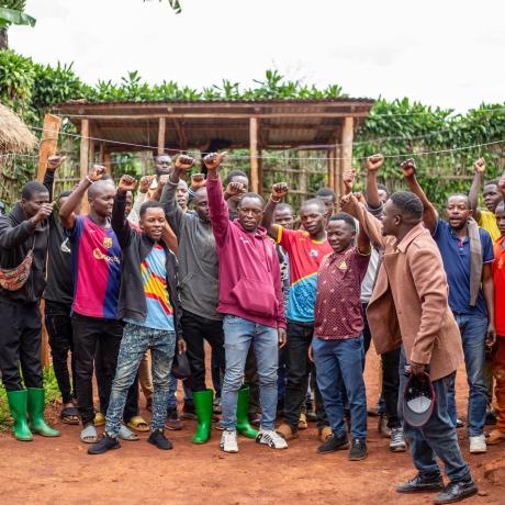 Community members in Walungu, South Kivu, raise their hands after a Community Scorecard meeting assessing the impact of the GAFSP-supported RENUGL project. The session brought farmers together to reflect on challenges affecting agriculture, markets and security, highlighting how collective dialogue and local action are essential to building resilience beyond agricultural production.